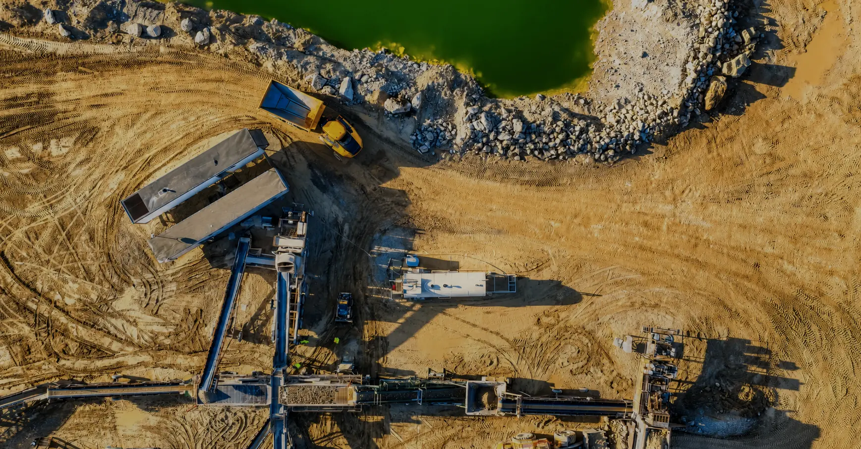 Aerial view of a mineral processing operation with tailings pond and haul truck